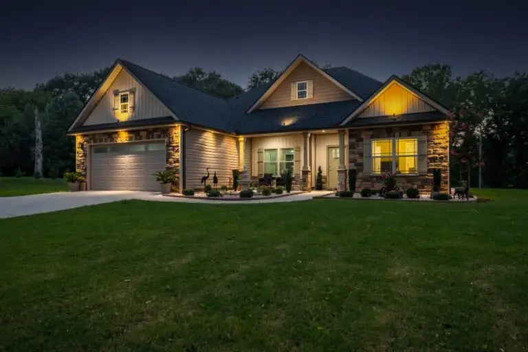 Single family home lit up by outside lights at dusk