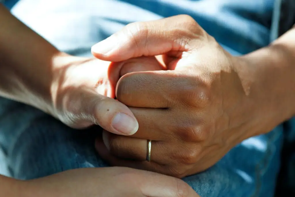 Close up on two woman holding hands