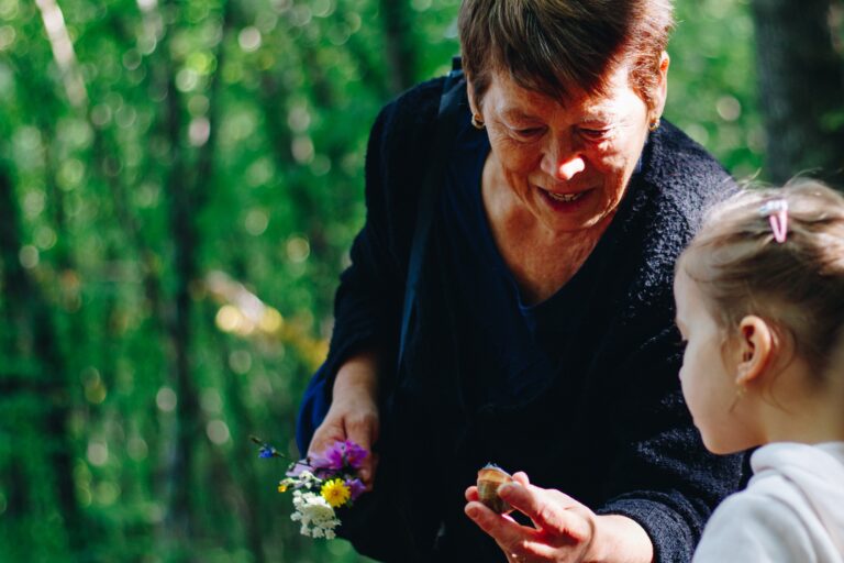 Grandmother picking flowers with her granddaughter